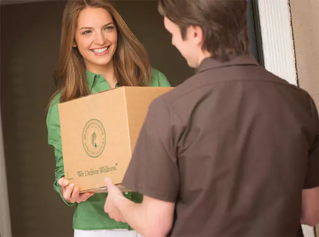 delivery man giving a women her melaleuca box