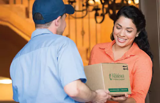 delivery man giving melaleuca box to a women