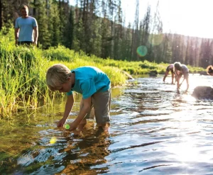 Kids and dad in river on earth day