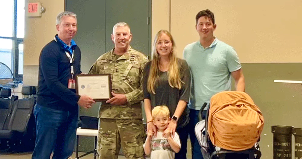 Major General Michael Garshak presented the Patriot Award to Melaleuca IT Director James Andersen, Sgt. Stephen Herriott, his wife Emily, and their two children